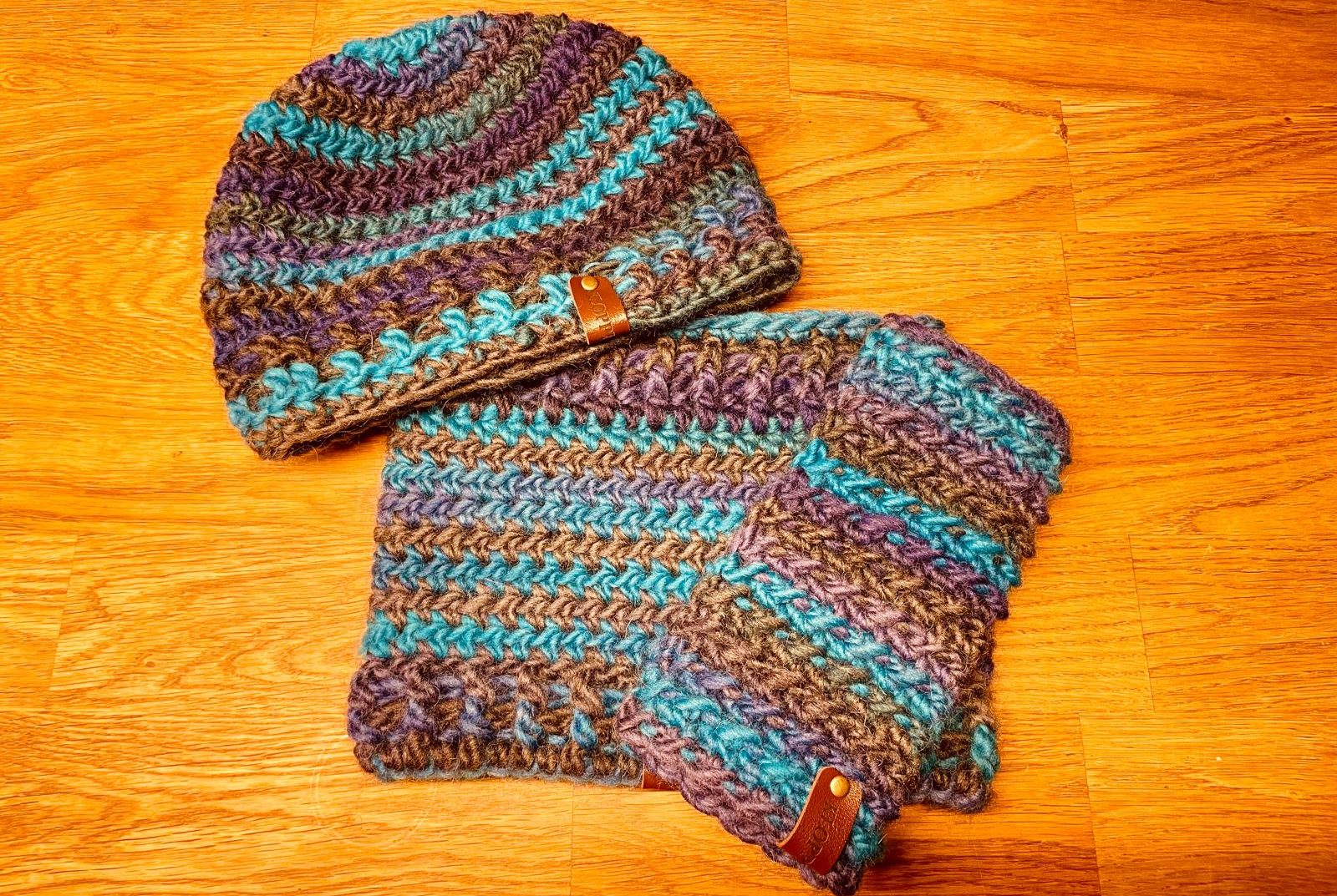 Bunte Armbänder aus geflochtenem Material auf einem Holzstamm, umgeben von Moos.